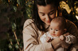 © Ananass - authentic portrait of mother and newborn daughter in her arms. A woman rejoices, hugs and kisses a child, talks and rejoices her daughter, happy smiles on the face of mother and baby