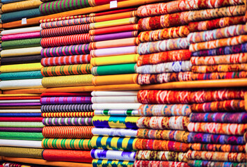 Shot of the many textiles with different ornaments and textures on top of each other in the shop.