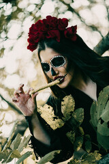 Wall Mural - Vertical shot of a woman with spooky Halloween makeup, eating a snack shaped like a finger