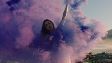 Woman Dancing With Purple Smoke Bomb On Beach Celebrating Creative Expression With Playful Dance Spin In Slow Motion