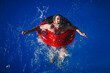 © Cavan Images - 66-year-old man enjoying a sunny day in the pool with a red float