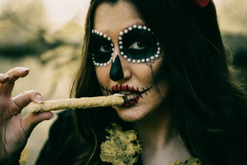 Wall Mural - Shallow focus shot of a woman with spooky Halloween makeup, eating a snack shaped like a finger