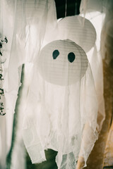 Wall Mural - Vertical shot of spooky Halloween decorations, a hanging handmade white ghost