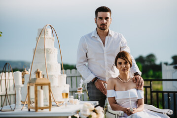 Canvas Print - Beautiful Serbian bride and groom near the wedding cake, at their outdoor reception