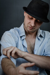 portrait of a young man with a hat that rolls up his shirt sleeves