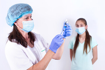 Wall Mural - female pediatric doctor or nurse gives an injection or a vaccine to patient - young girl. Vaccination against influenza, pandemic coronavirus. Mandatory prevention of people for immunity from virus.