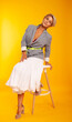 © Marina Chernivetskay - a woman with a suitcase on a yellow background in isolation. Traveler