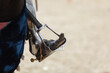 Close-up of the rider's leg in historical armor on a horse. Shoes with a long nose in metal protection in stirrups. Copyspace