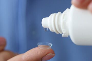 Canvas Print - Woman drips liquid into contact lens for eyes closeup