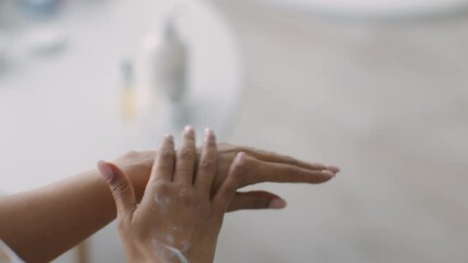 Wall Mural - Beauty treatment. African american woman rubbing hands, applying seasonal protection in morning, lady pov, free space