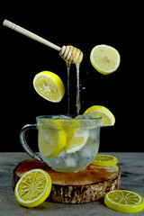 Wall Mural - Vertical shot of floating honey dipper on an iced lemonade - perfect for drink menu