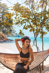 Wall Mural - Beautiful young fashionable woman in black dress posing at the beach