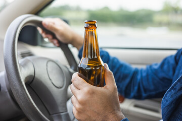 Young man drinking beer while driving Risk of accidents due to drunk driving