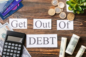 Poster - Composition with text GET OUT OF DEBT and money on wooden background