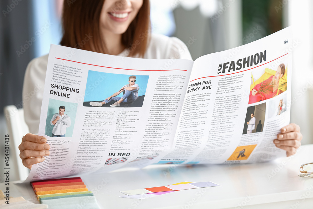 Young woman reading newspaper at home