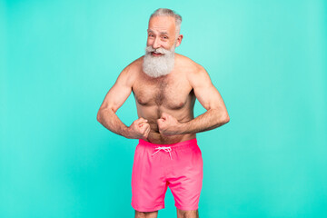 Wall Mural - Photo of flirty retired old man show strength arms muscles wear pink shorts isolated teal color background