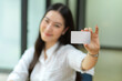 © bongkarn - Happy young woman hold blank business card for mockup, credit card mockup