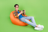 Fototapeta Panele - Photo of funny excited crazy guy hold gamepad play video game wear plaid shirt jeans shoes isolated green color background