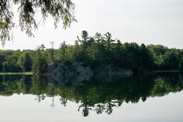 Sticker - Lake reflecting surrounding trees and the daytime sky in Sudbury, Ontario, Canada