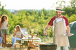 © Pixel-Shot - Young man cooking food on barbecue grill outdoors