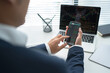 © PBXStudio - Businessman using smartphone. He is analyzing data with trading charts.