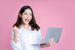 © PBXStudio - Portrait of an excited black long hair girl holding laptop computer and celebrating success isolated over pink background