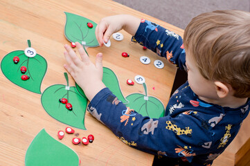 Wall Mural - put correct amount of ladybird on assigned tree leaf. baby playing counting game. preschool educational aid for kindergartens. children early learning montessori kit for intelligence and development