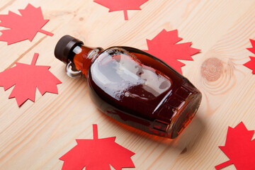 Wall Mural - Beautiful Canadian maple syrup in a bottle on a light wooden background. Pancakes with syrup or honey.
