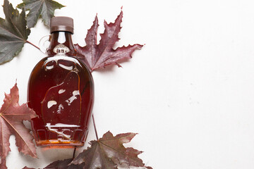 Wall Mural - Beautiful maple syrup in a bottle. Maple leaves
