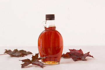 Wall Mural - Beautiful maple syrup in a bottle. Maple leaves
