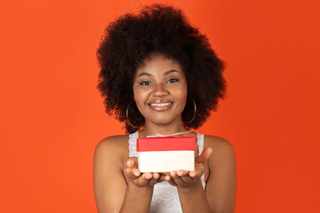 Wall Mural - attractive cheerful african woman holding a gift 