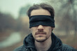 a man with a black blindfold over his eyes