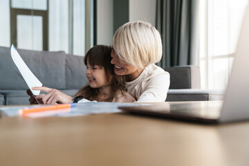 Canvas Print - Mother helping her daughter with her homework