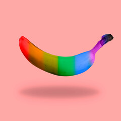 A rainbow colored banana on a pink background as a gay pride symbol.