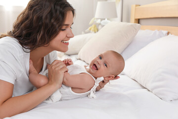 Sticker - Happy young mother with her cute baby on bed at home