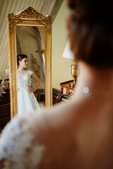 Wall Mural - the bride at the mirror. selective focus. trying on a wedding dress 