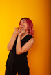 © Marina Chernivetskay - a girl of European nationality greedily looks at a piece of pizza wants to eat it on a yellow background with a place for the text