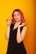 © Marina Chernivetskay - a girl of European nationality greedily looks at a piece of pizza wants to eat it on a yellow background with a place for the text