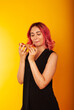 © Marina Chernivetskay - a girl of European nationality greedily looks at a piece of pizza wants to eat it on a yellow background with a place for the text