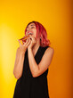 © Marina Chernivetskay - a girl of European nationality greedily looks at a piece of pizza wants to eat it on a yellow background with a place for the text