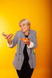 © Marina Chernivetskay - a girl of American appearance with two pizzas in her hands on a yellow background advertising fast food