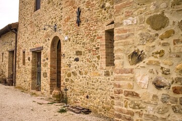 Wall Mural - The facade of a rural stone farmhouse with wooden doors and windows in the italian countryside (Tuscany, Italy, Europe)