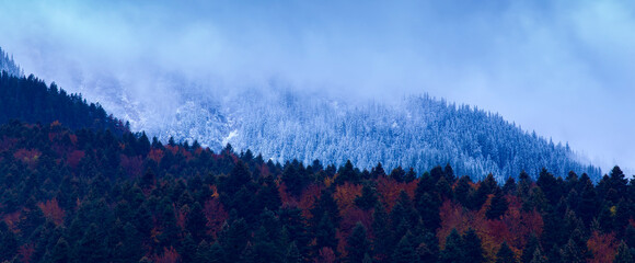 Wall Mural - Contrast of two seasons in one image: autumn and winter after sunset. 