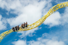 Ride Roller Coaster In Motion In Amusement Park.