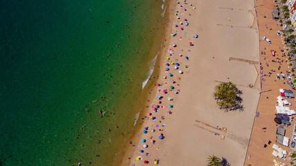 Tomas cenitales y aéreas de la ciudad y la playa de Villajoyosa en Alicante con gente tomando el sol con sus sombrillas y bañándose en el mar