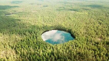 Wall Mural - Cinematic shot , aerial view of Forest woods and calm tranquil round shape lake. Fat white clouds reflecting on water surface. Finland