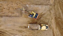 Aerial Top Down Footage Of Excavator Digger Loading Sand Into Sand Truck