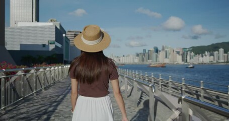 Poster - Woman walk at the water promenade in Hong Kong