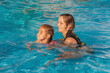 © Vit-Vit - A young woman and a girl swim in clear water in a water park. A young mother with her daughter in a water park on a sunny summer day in the open air. Summer active recreation.