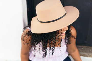 Portrait of a beautiful teenage girl with hat and curly hair